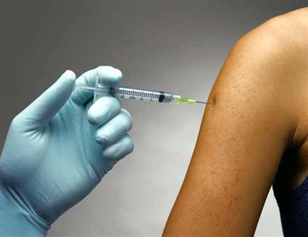 Bare arm receiving a shot with a syringe