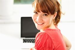 Girl smiling at computer desk. 