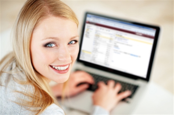 Smiling girl at laptop keyboard                                                                                                             