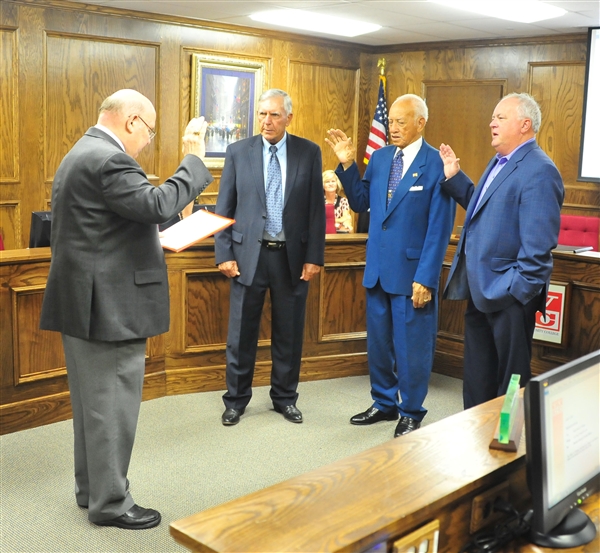 Henderson County Justice of the Peace Randy Daniel administers the oath of office to TVCC board members Jerry Stone, Homer Norville and Dr. Charlie Risinger.