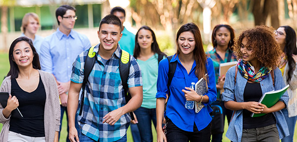 group of racially diverse students smiling, walking