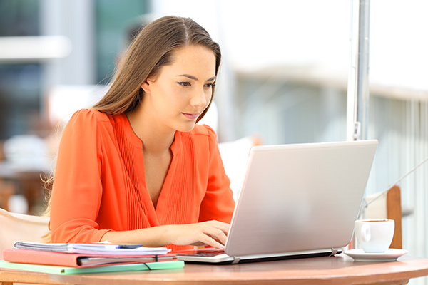 College-aged girl studying laptop computer.