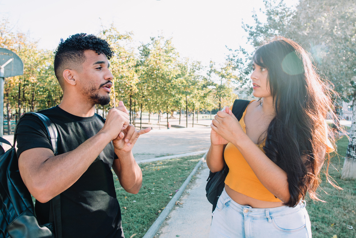 2 hispanic and african american student friends deaf talking with nonverbal communication