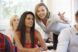 professor talking to a student and pointing at an object                                                                                    