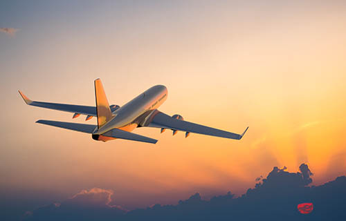 Passanger airplane flying above clouds in evening.