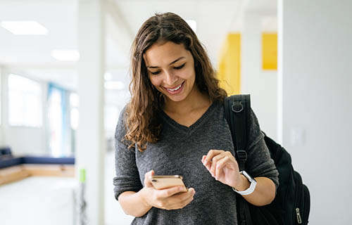 Young woman using smartphone at university