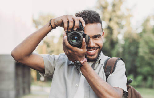 young man looking through a camera 