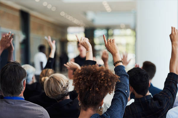 room of people raising their hands