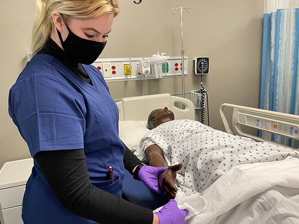 nursing student learning on a mannequin