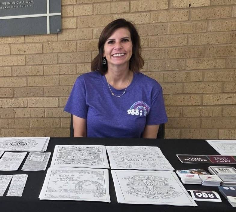 Amanda Schmidt sitting behind a table with informational resources on it