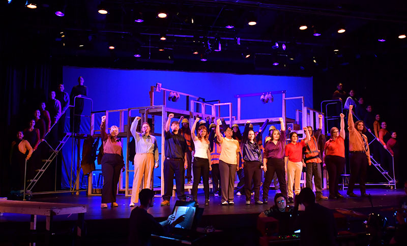 Students on stage in a theatre production posing for curtain call