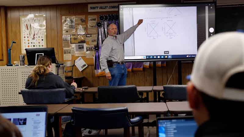 Instructor Marc Robinson standing in front of a large screen to teach a class about agriculture