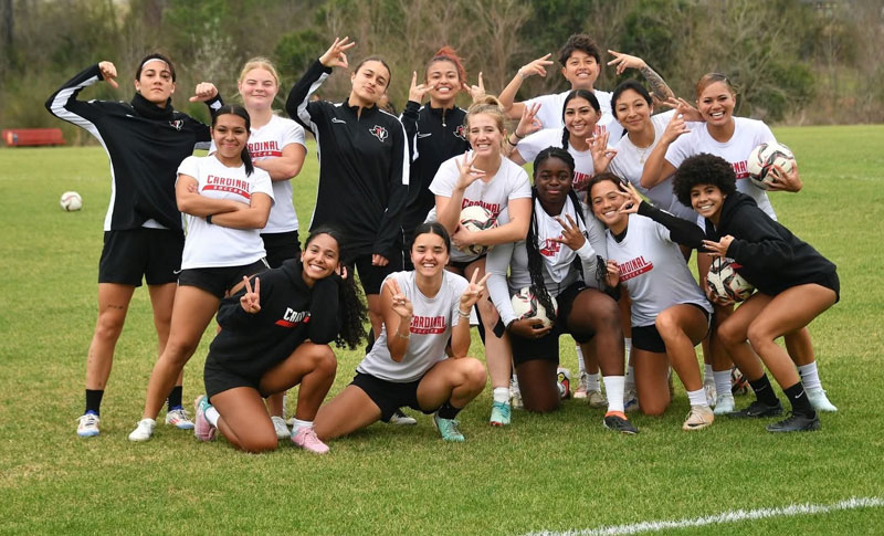 TVCC students huddled together on the soccer field for a group photo