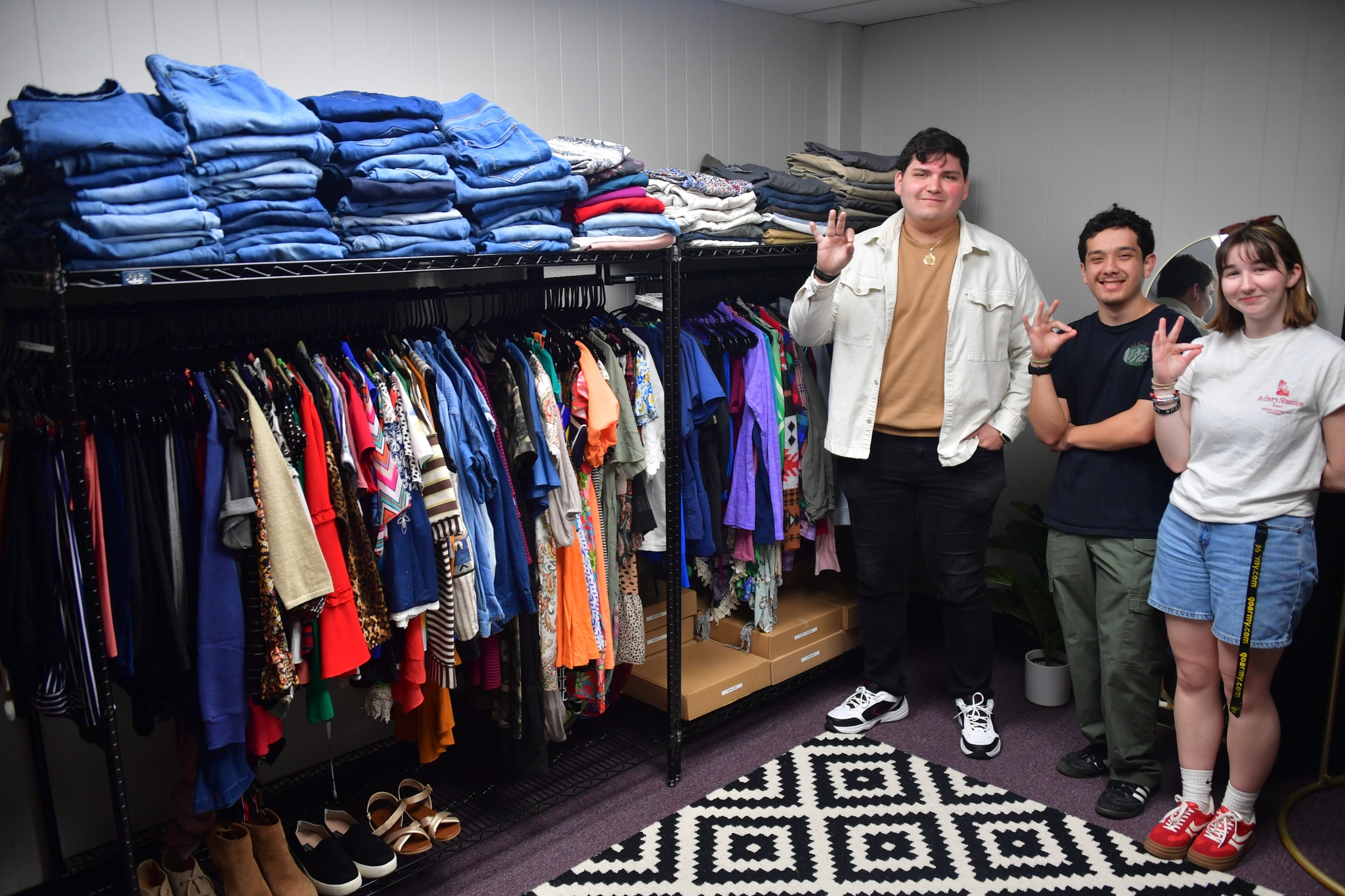 Students in the Cardinal Resource HQ standing next to a shelf of clothing