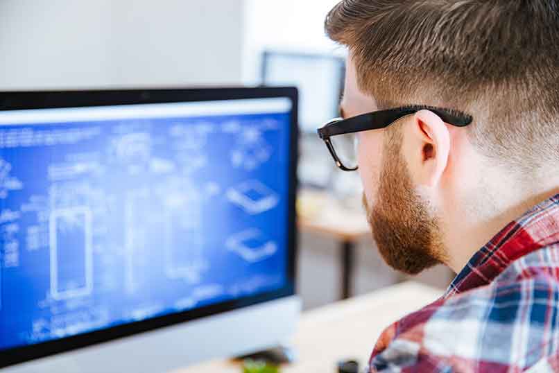 Man working on a digital blueprint at a desktop computer