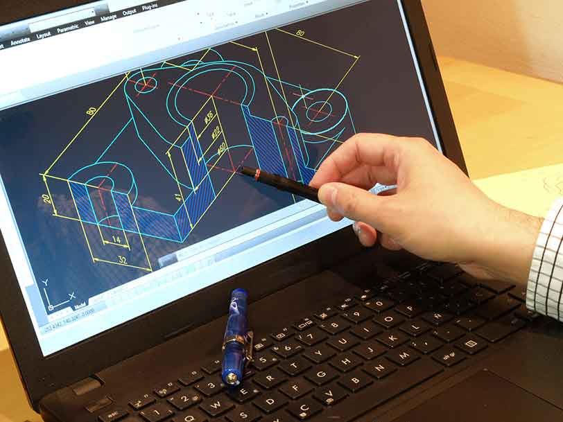 Person pointing with a pencil at a digital draft on a laptop
