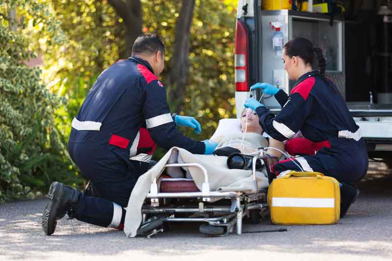 Two paramedics providing care to a child on a stretcher
