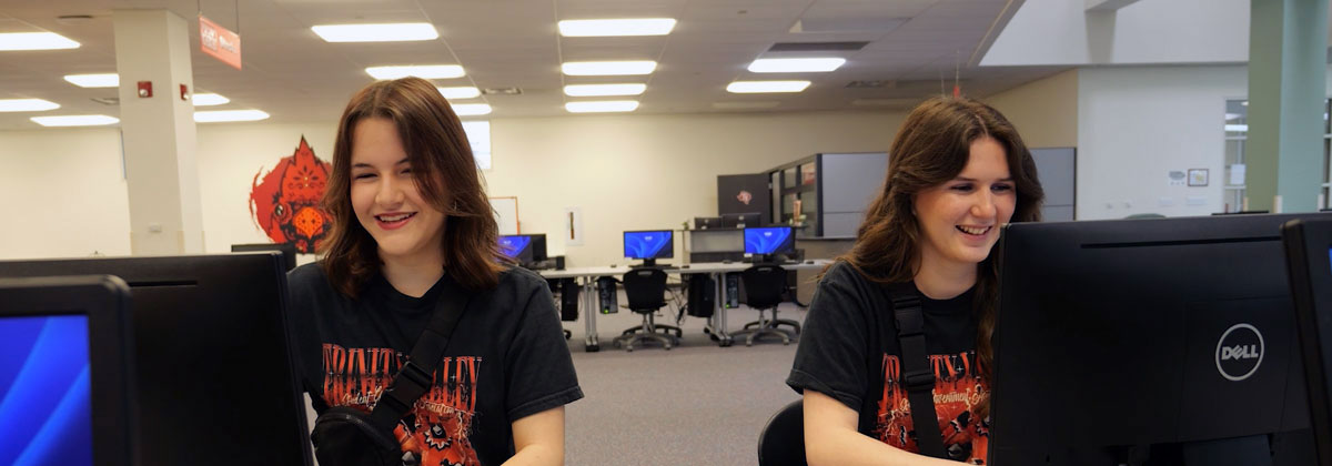 two students operating a computer in the campus computer lab
