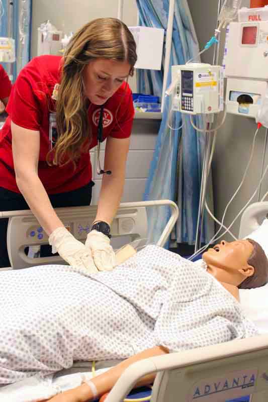 Female nurse practicing CPR on a manakin