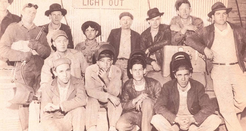 Black and white photo of a group of men in a TVCC welding class