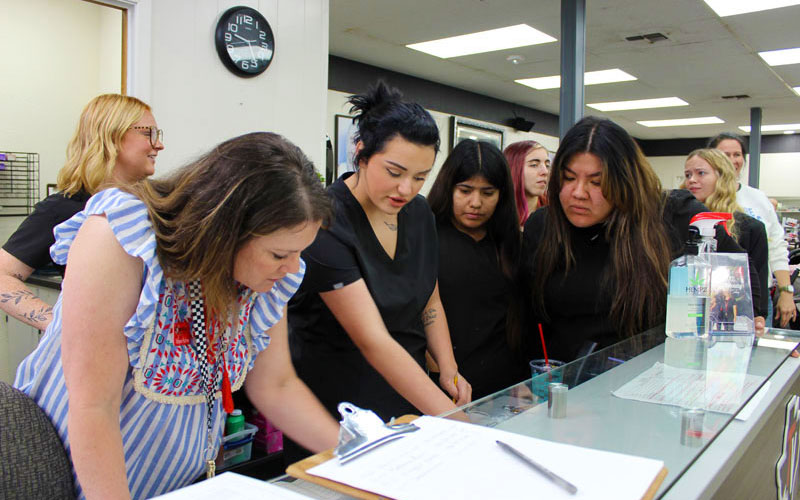 a group of students around a table observing their instructor