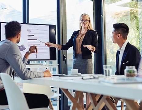 woman in professional attire leading meeting in conference room