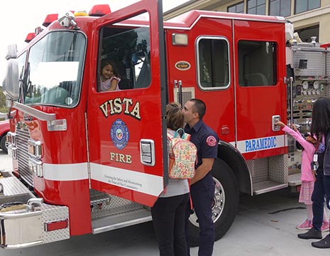 fireman giving school children a tour of a firetruck