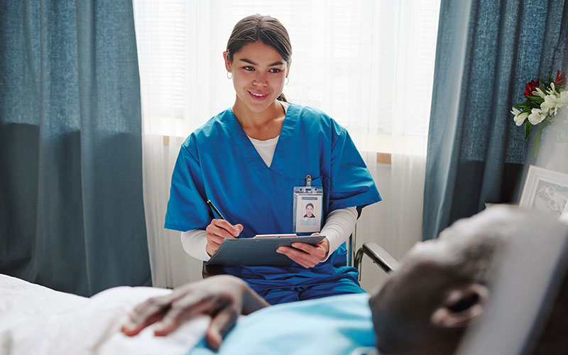 Patient care technician taking notes of patient