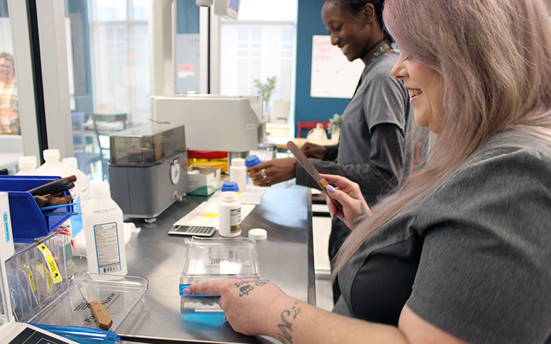 Two female pharmacy technicians preparing medication