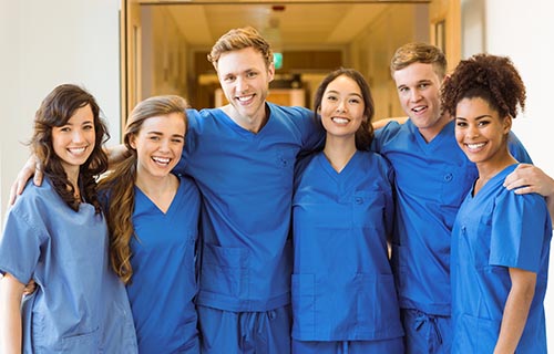 smiling nursing students standing arm in arm