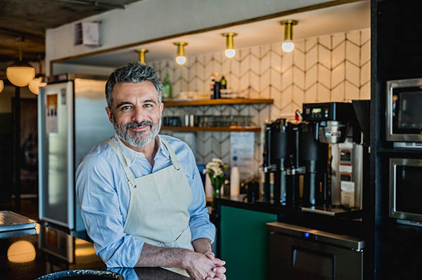 man wearing apron standing in kitchen